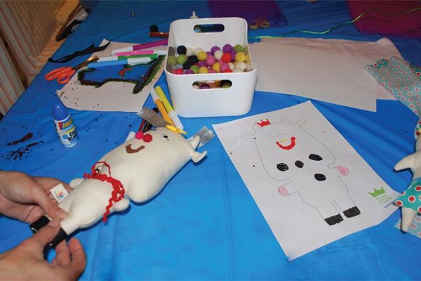 Foto niño trabajando muñeco de tela taller Reyes Magos Deloitte