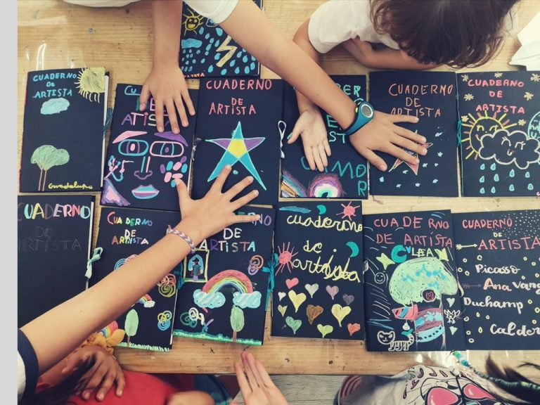 manos alumnos Arte sobre sus cuadernos de artistas