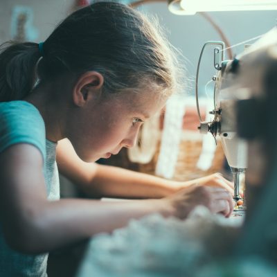 Niña cosiendo a maquina